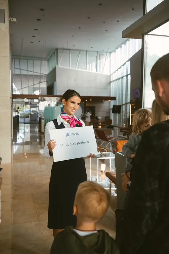 SkyVip greeter meeting travelers with a name sign